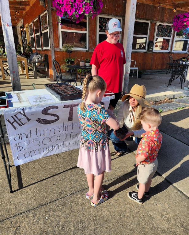 A group of people are standing around a table with a sign that says hey st.