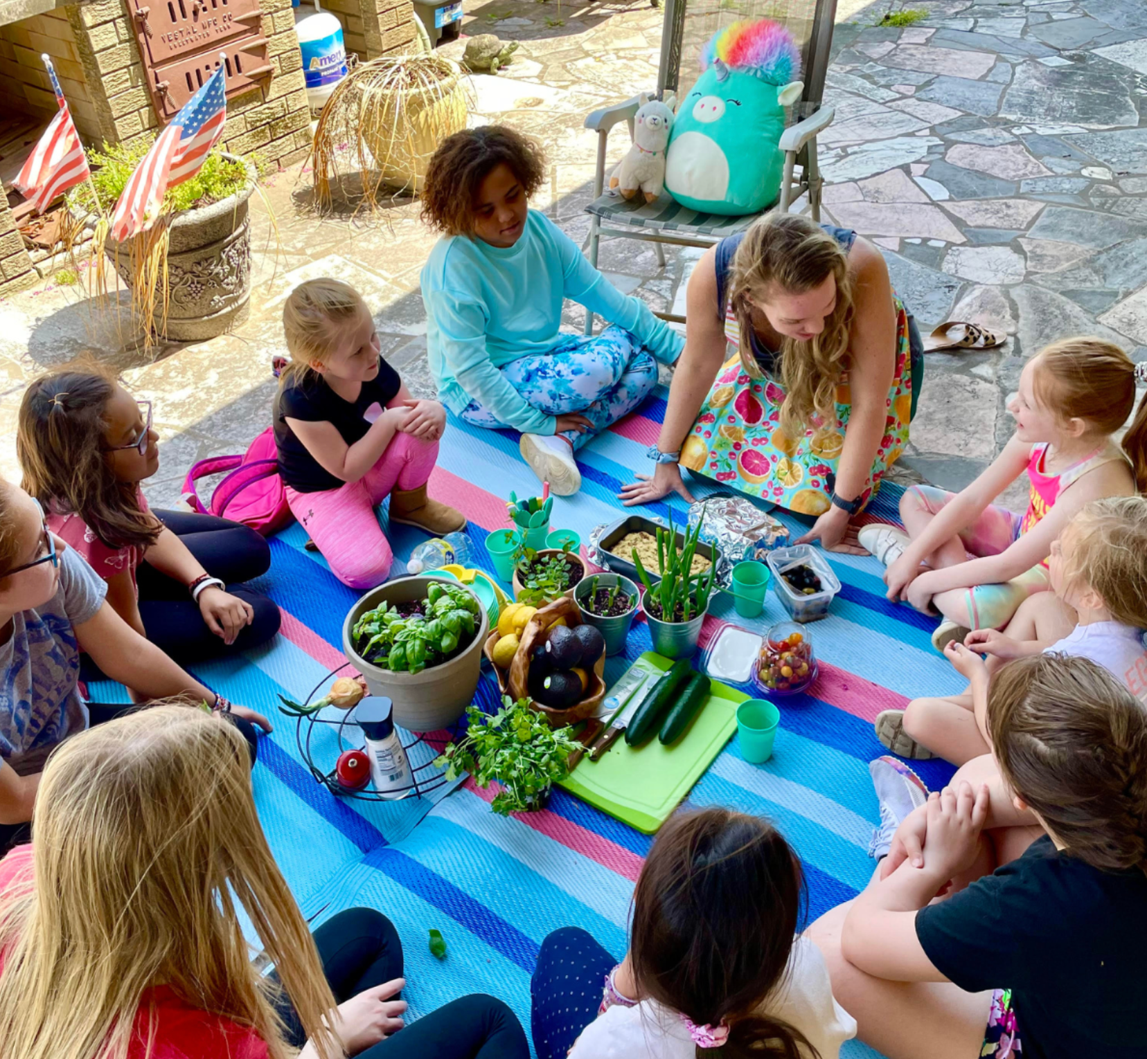 A group of people are sitting around a table with vegetables.