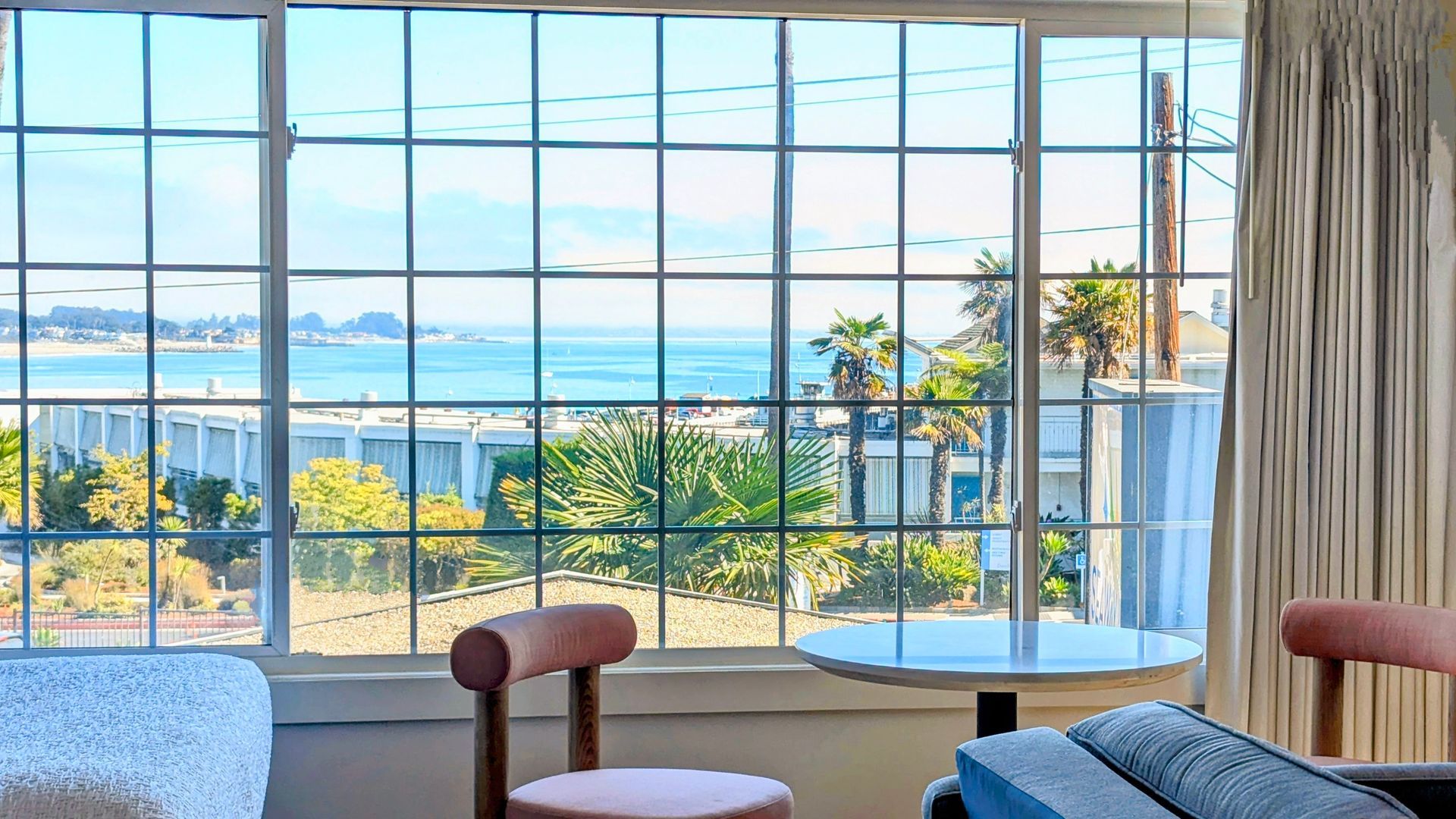 Table and chairs in front of window with ocean view