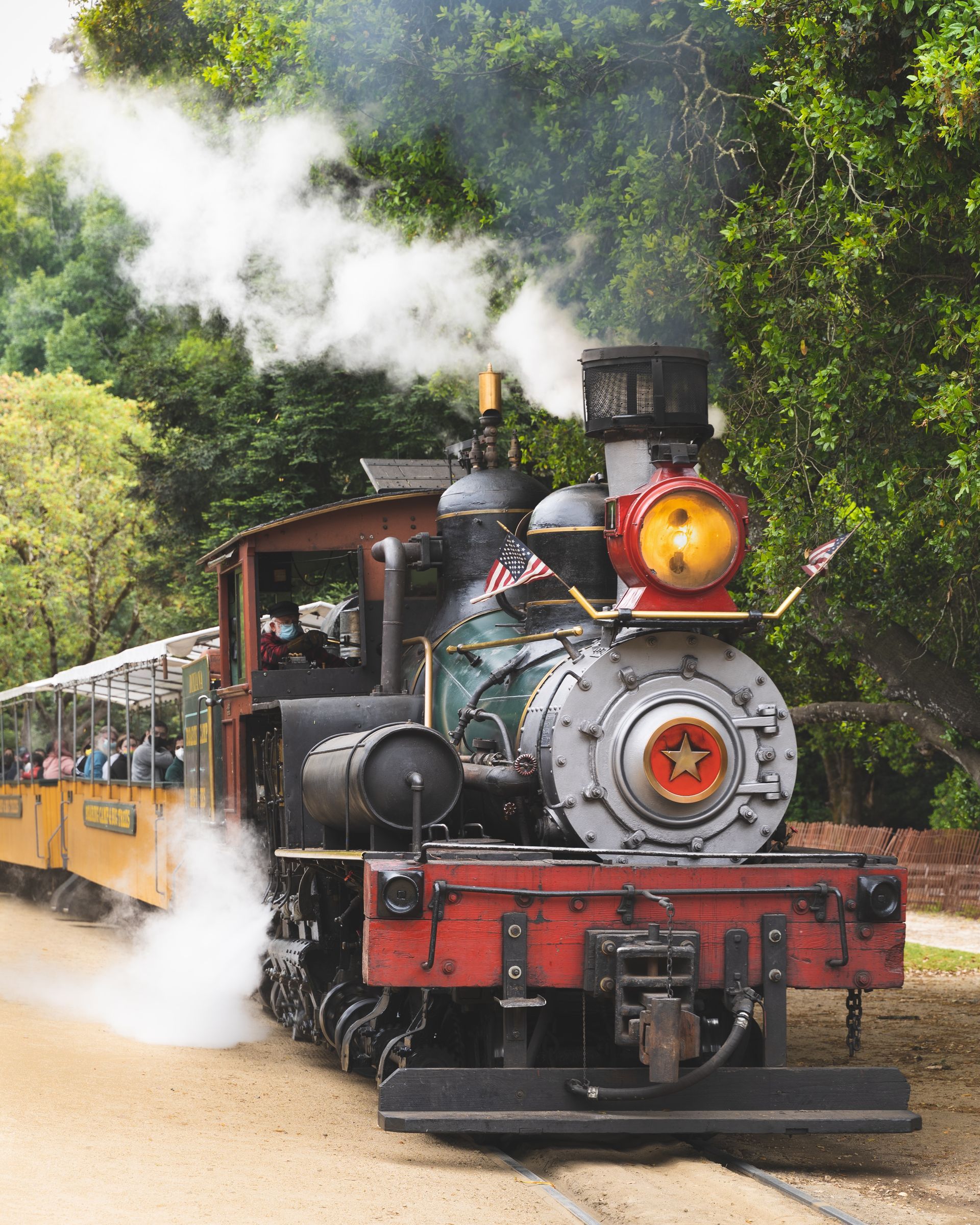 engine car of an antique steam train with steam coming out of the stack