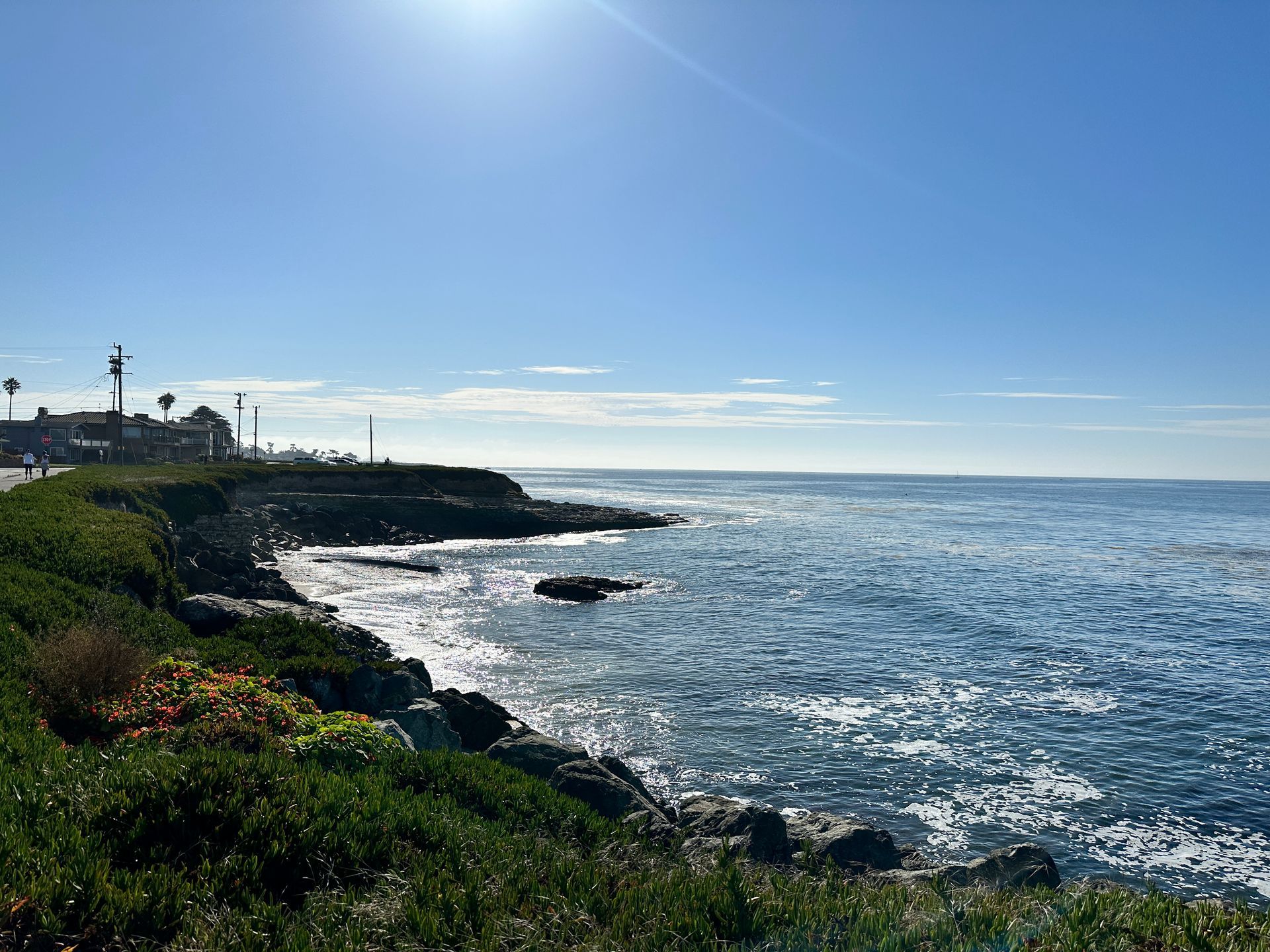 View of the ocean from the cliffs above with a house off to the left