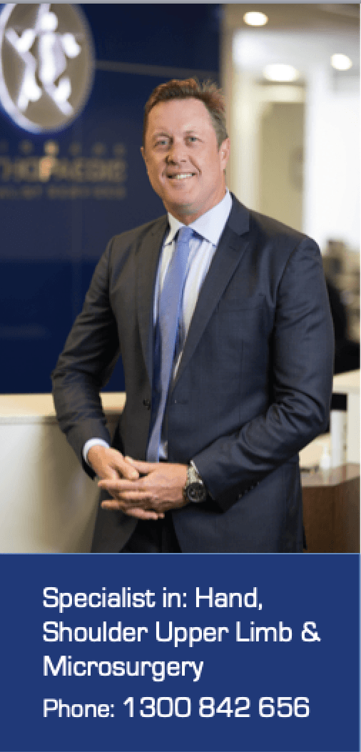 A man in a suit and tie is standing in front of a counter.