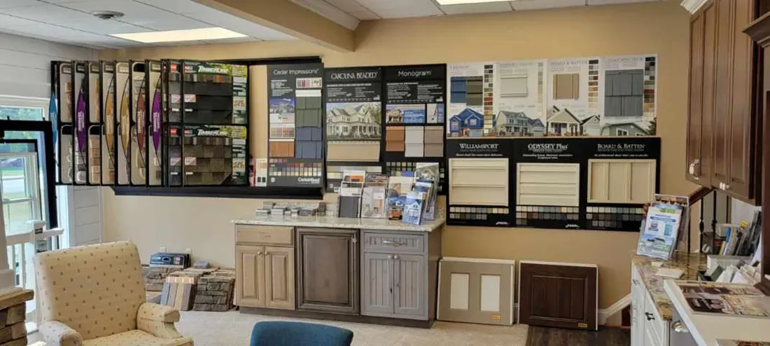 A showroom display featuring various cabinet doors, flooring samples, and design materials arranged on walls and counters.