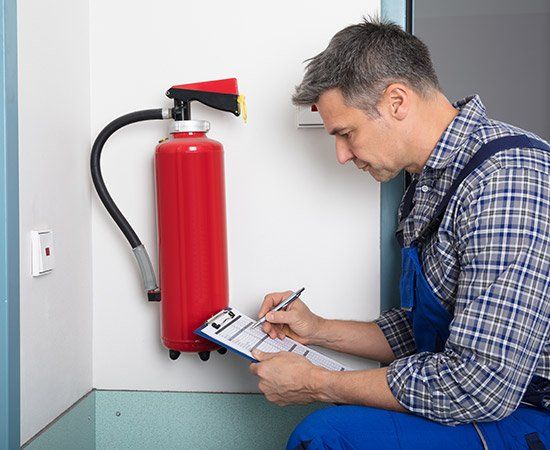 Man Inspecting Fire Extinguishers — Birmingham, AL — Automatic Fire Systems