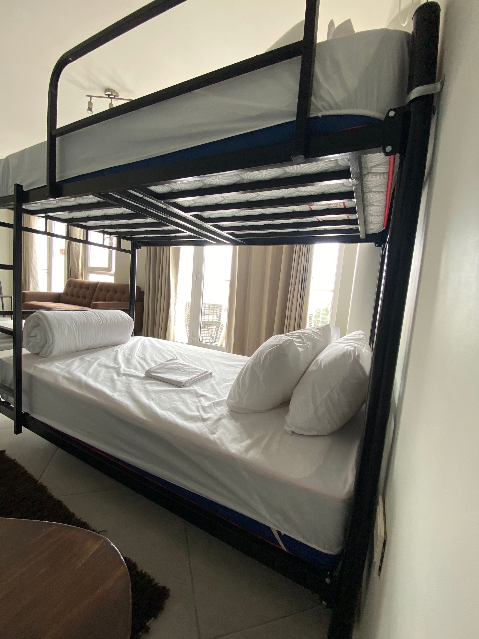 A bunk bed with white sheets and pillows in a room.