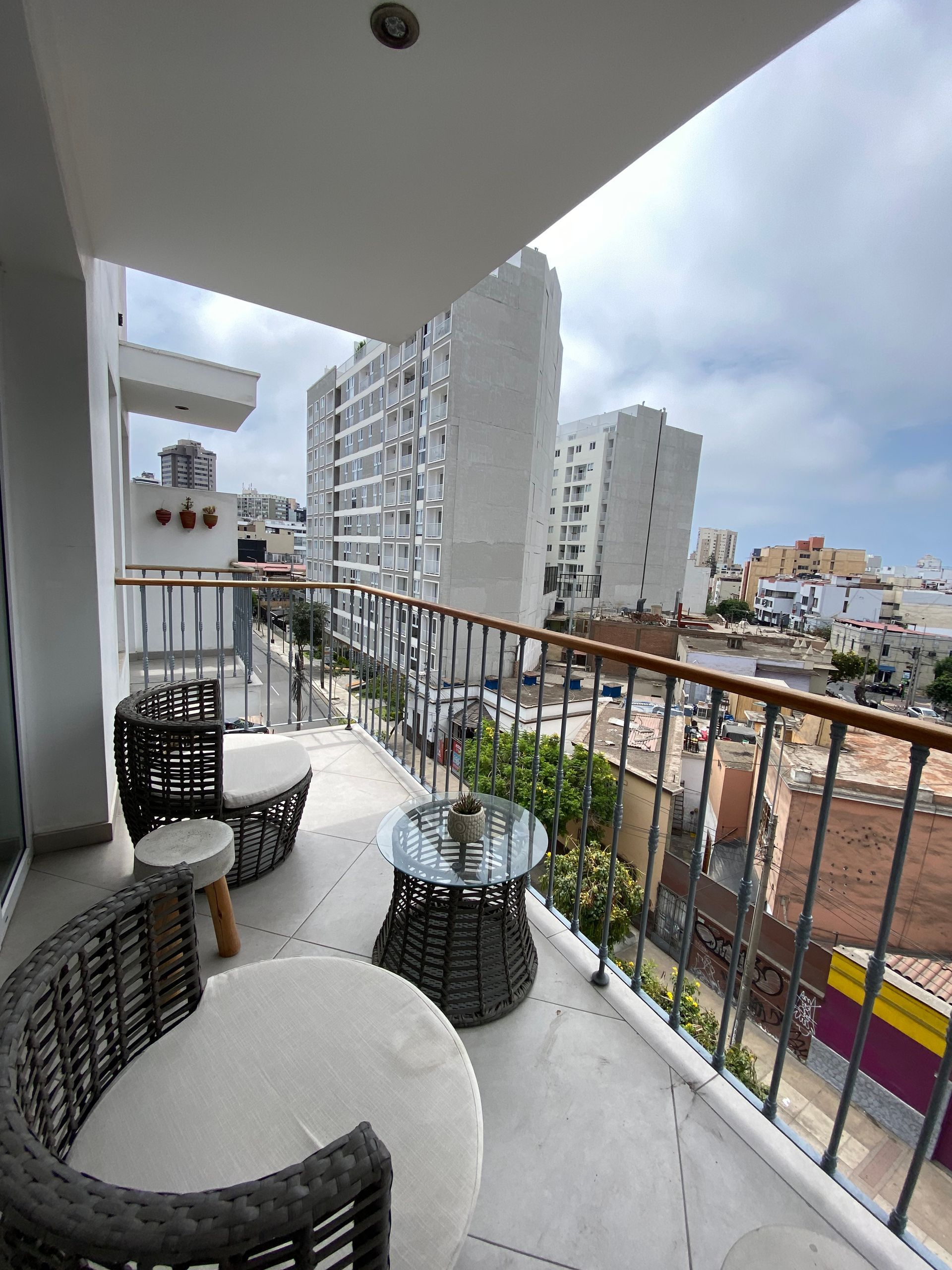 A balcony with chairs and a table overlooking a city