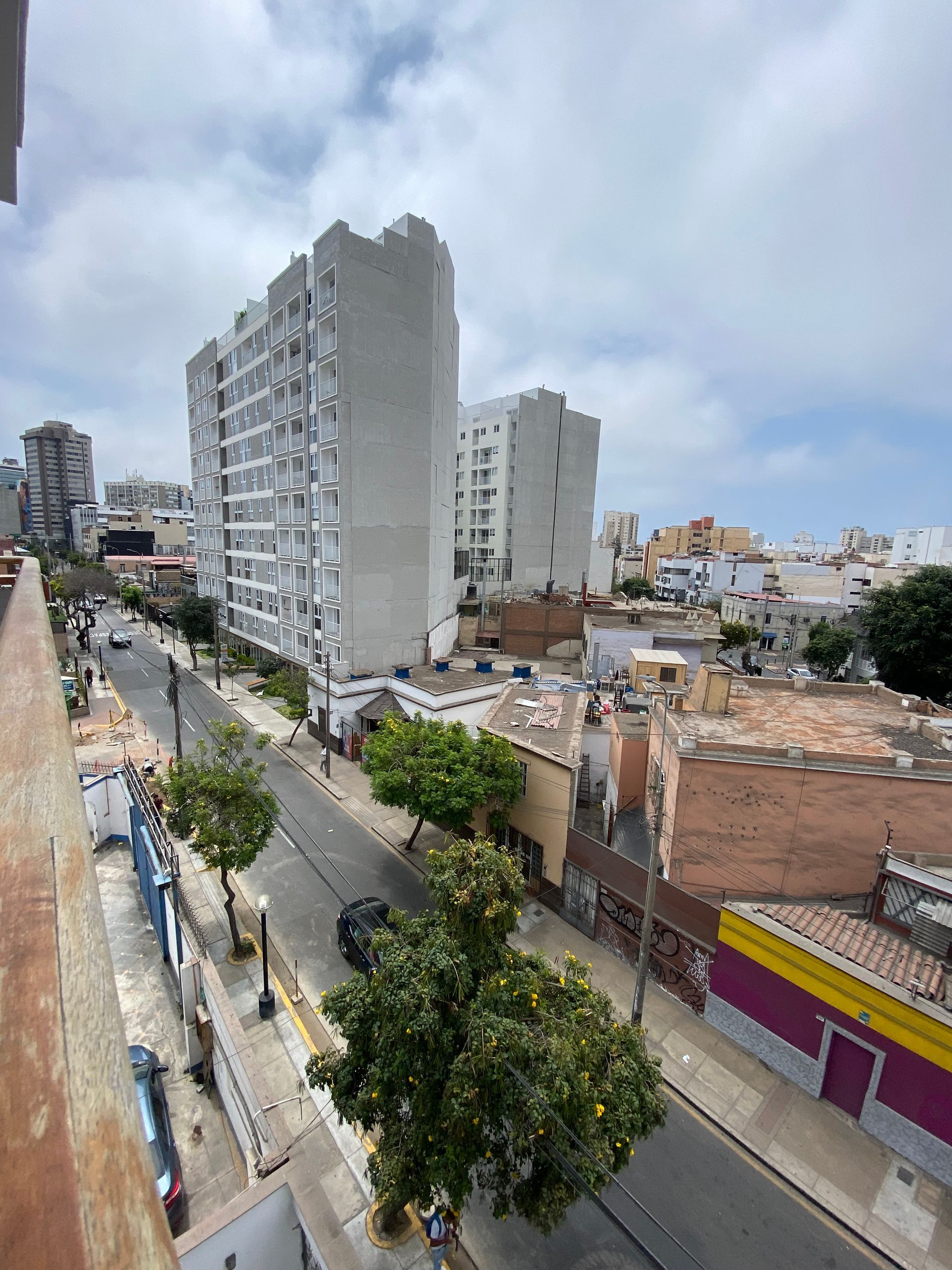 An aerial view of a city street with buildings and trees