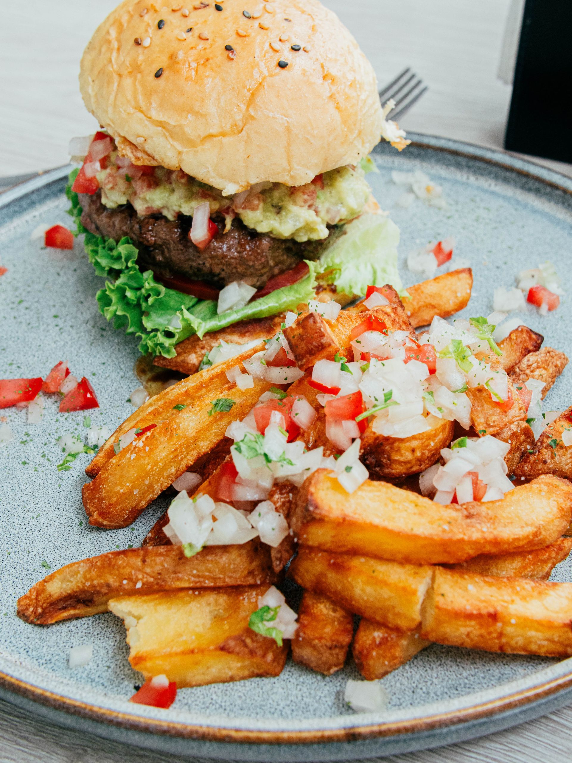 A plate of food with a hamburger and french fries on it.