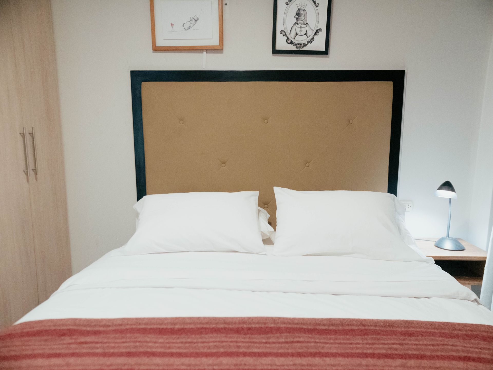 A bed with white sheets and pillows in a bedroom