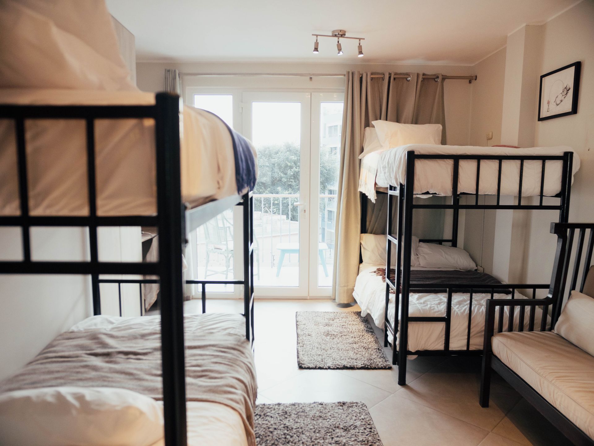 A room with four bunk beds and a couch.