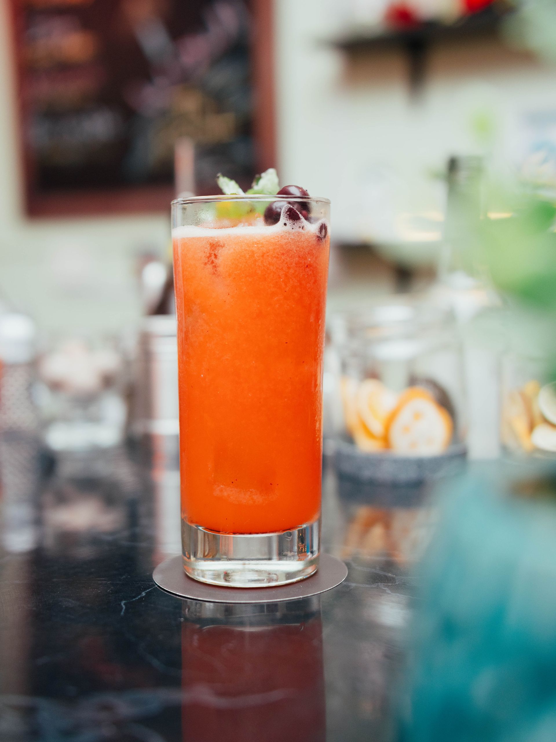 An orange drink in a tall glass on a table