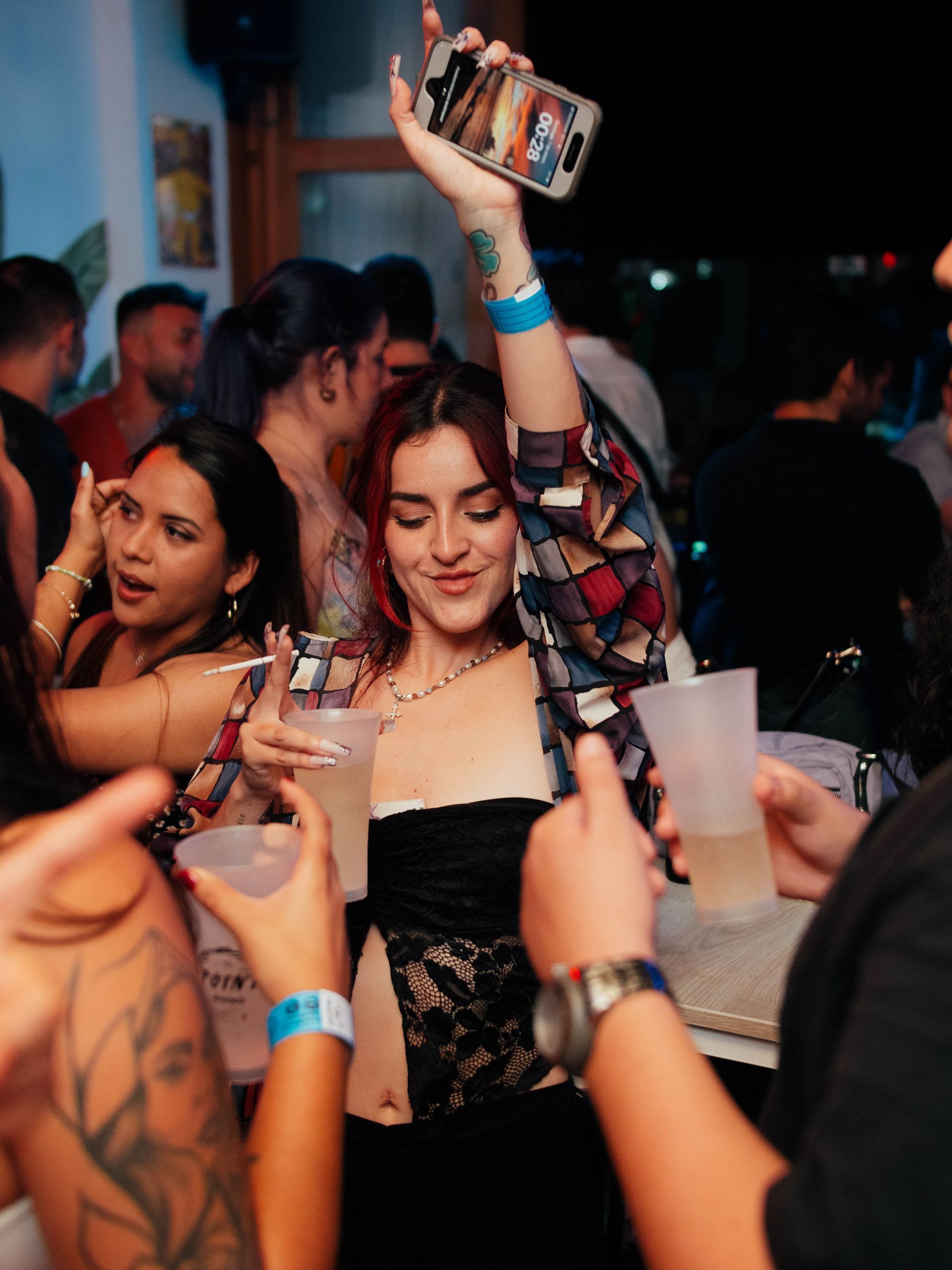 A woman is holding a bottle up in the air at a party