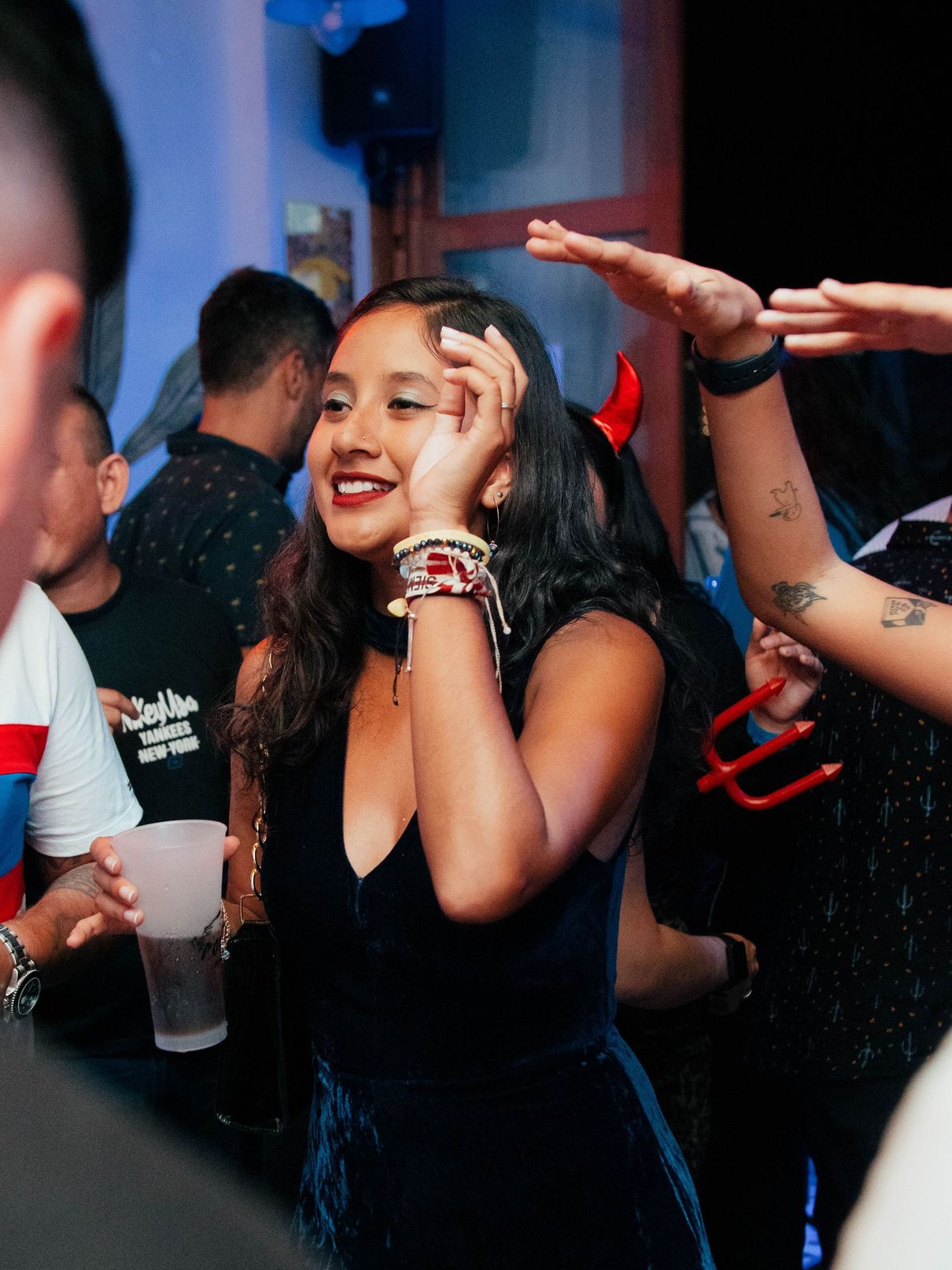 A woman in a black dress is dancing at a party