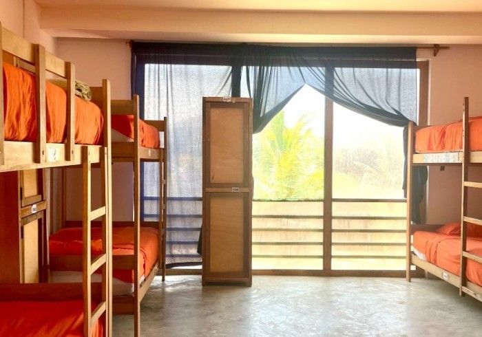A room with bunk beds and a large window
