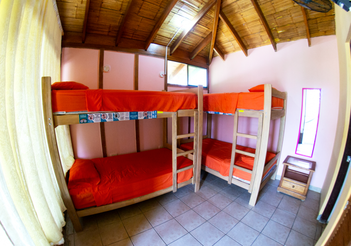 A room with three bunk beds and a mirror
