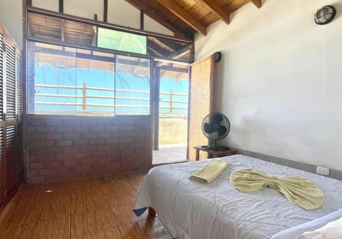 A bedroom with a bed , a fan and a window.