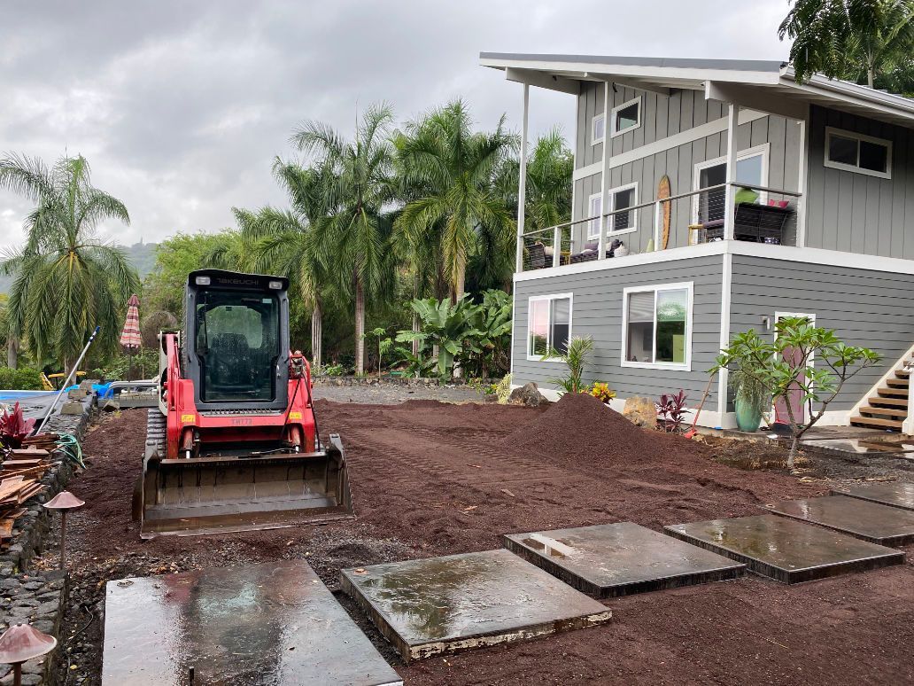 A bulldozer is moving dirt in front of a house doing grading. 