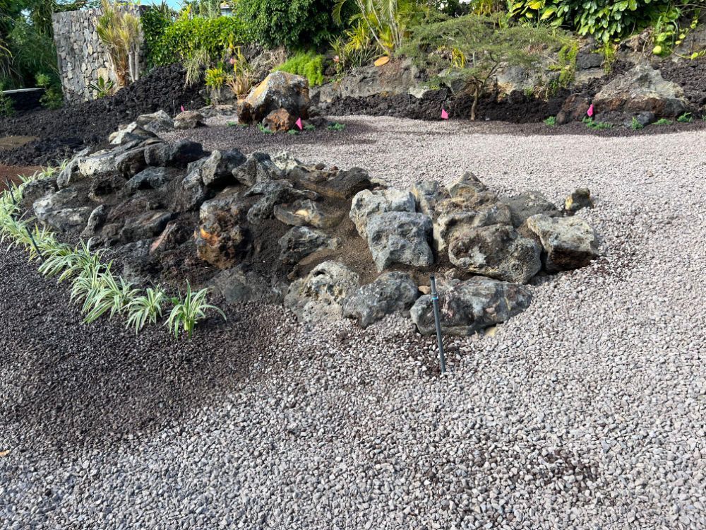 Grading and landscaping a pile of rocks is sitting on top of a gravel driveway.