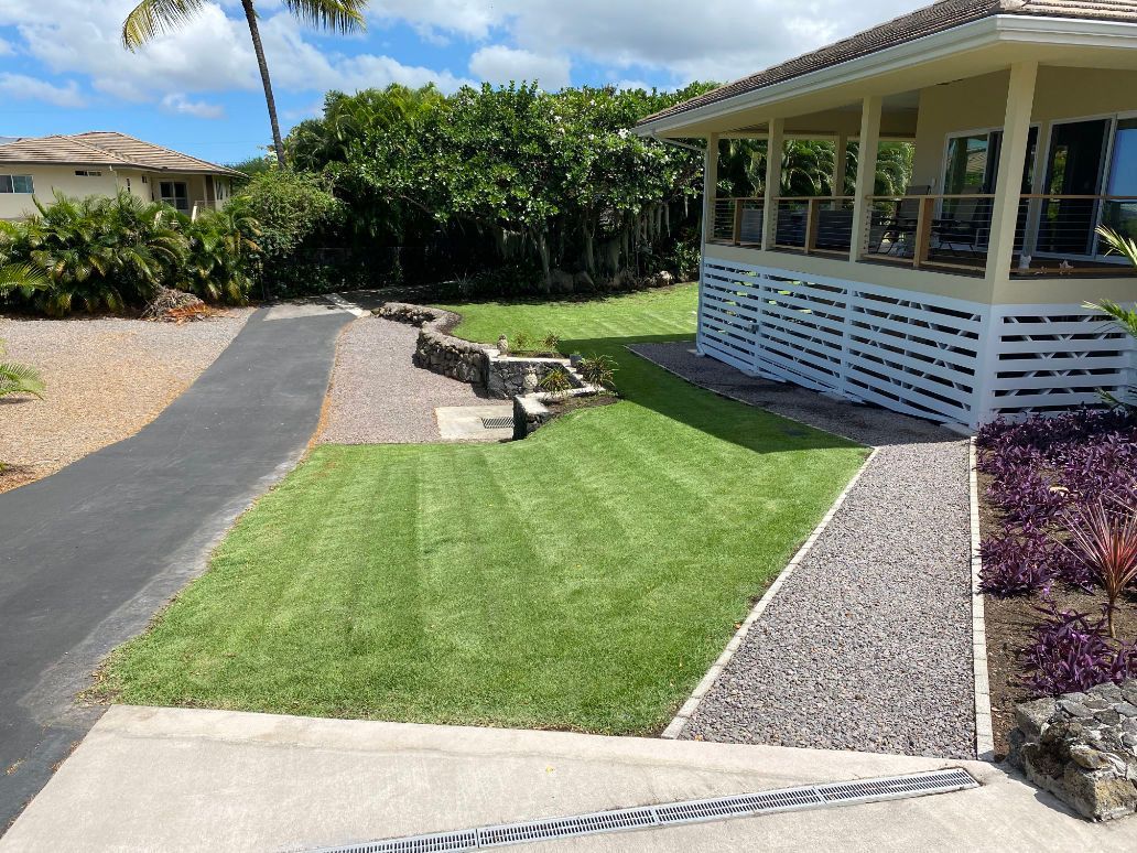 Sprinkler System and lawn installation for a house with a lush green lawn and a driveway leading to it.
