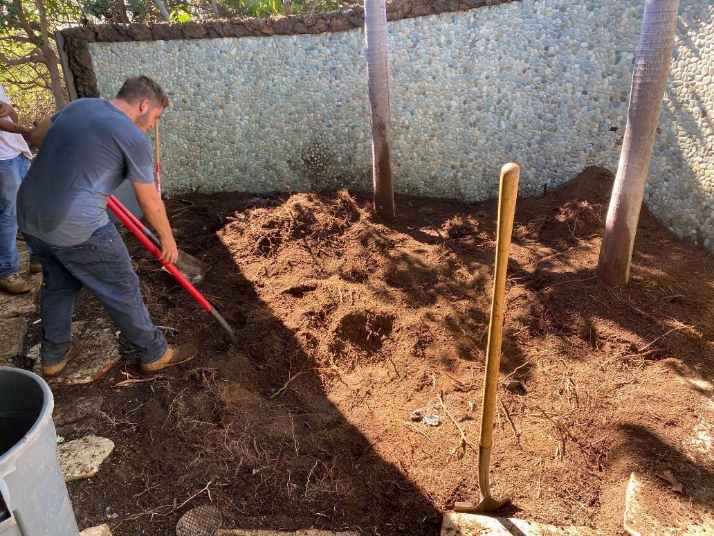 A man is digging in the dirt with a shovel showing landscape excavation project. 