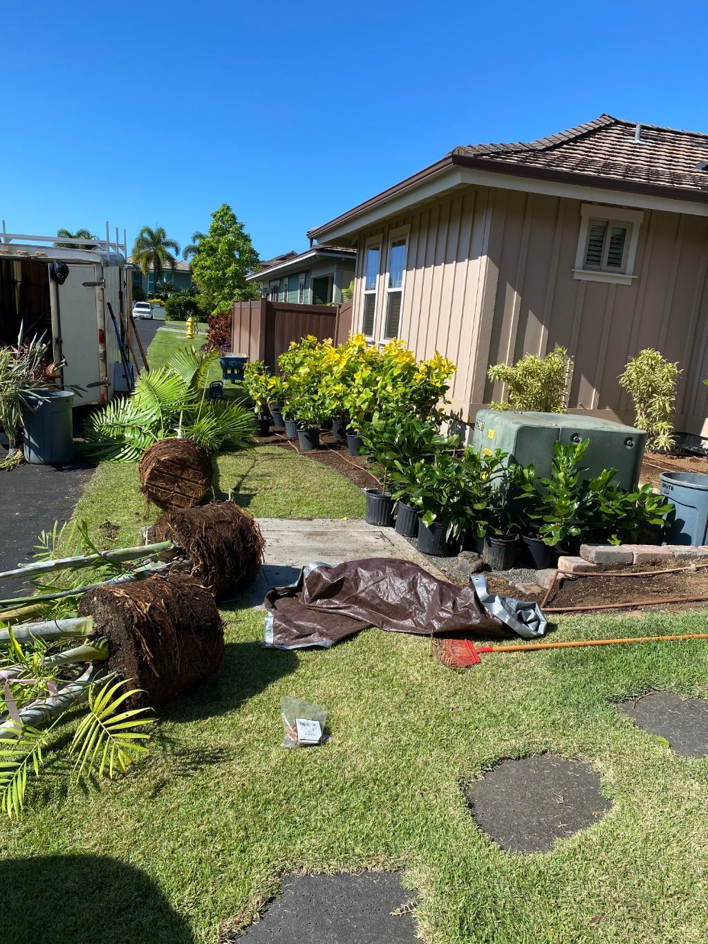 A house with a lot of potted plants in front of it showing a previous landscape contractors project, 