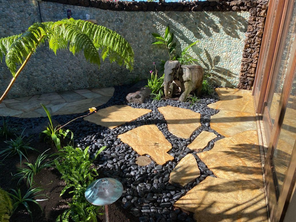 There is a statue of an elephant in the middle of the garden showing landscape installation project. 