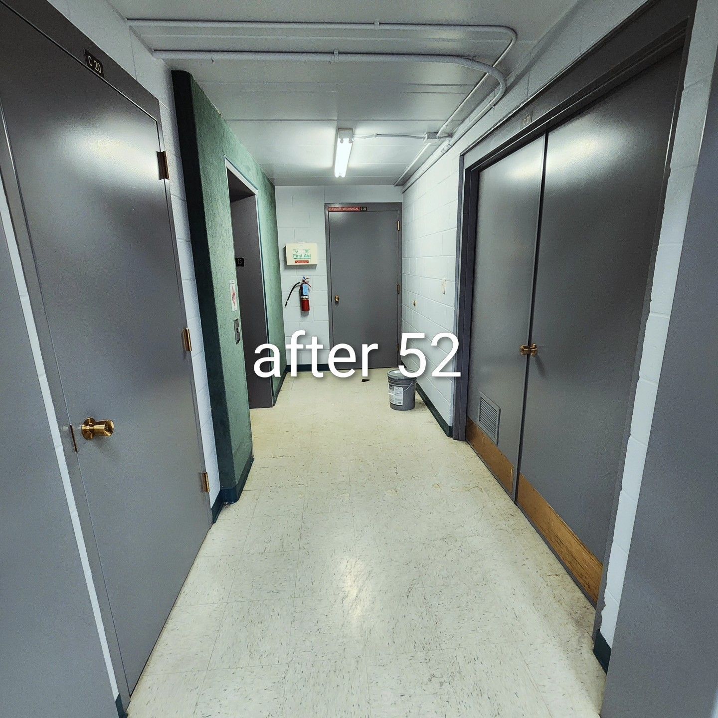 Narrow office hallway with gray doors and fluorescent lighting, labeled “after 52” in the center.