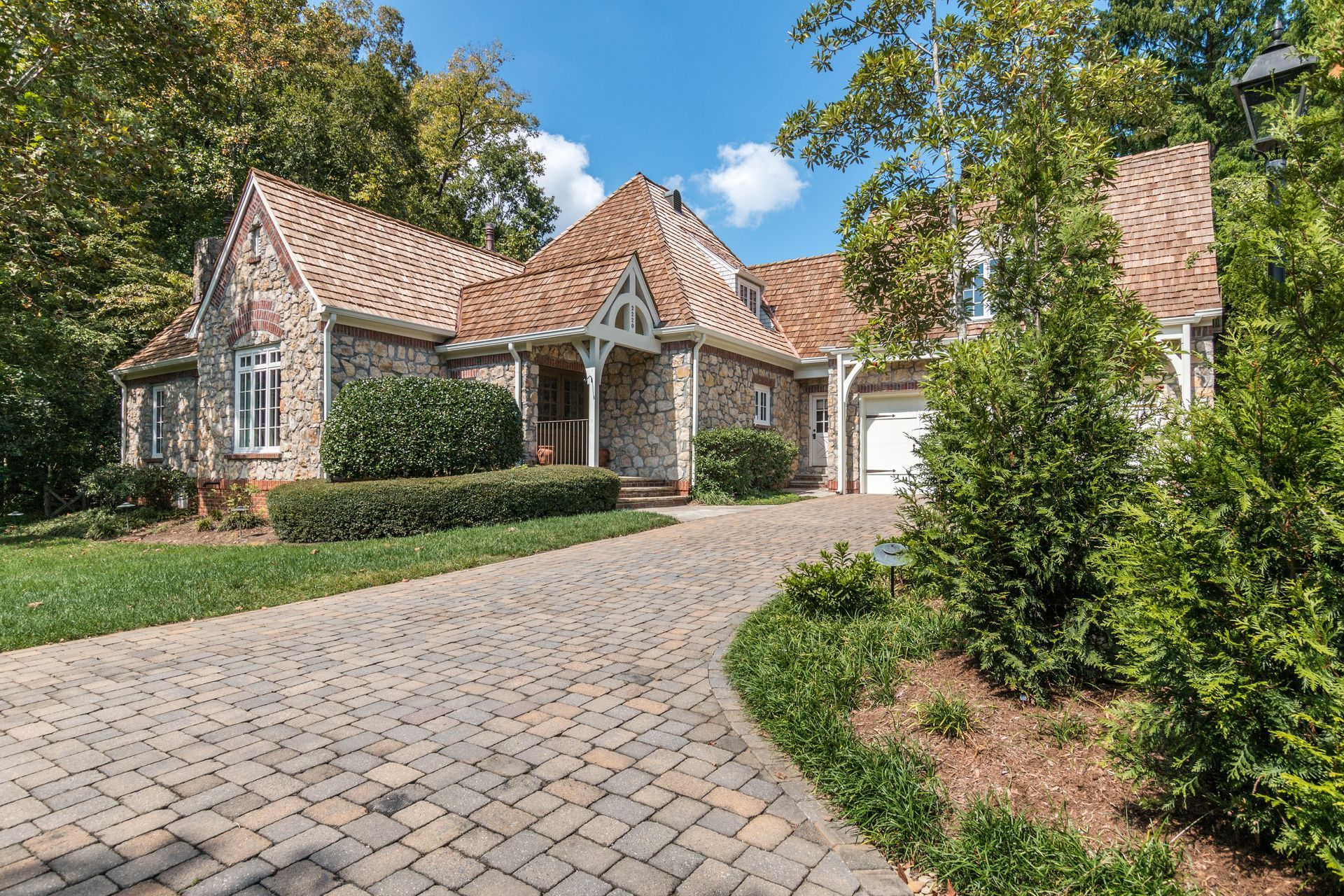 A large house with a brick driveway leading to it