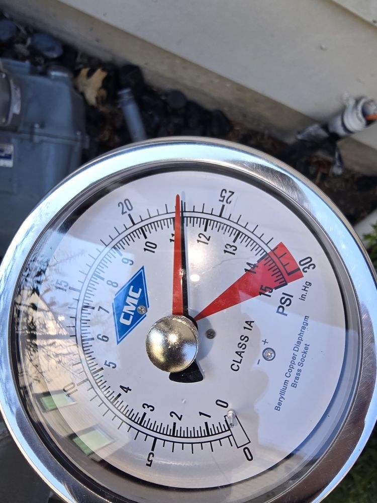 Pressure gauge showing approximately 12 PSI. Gauge is silver, with a white face and red needle.