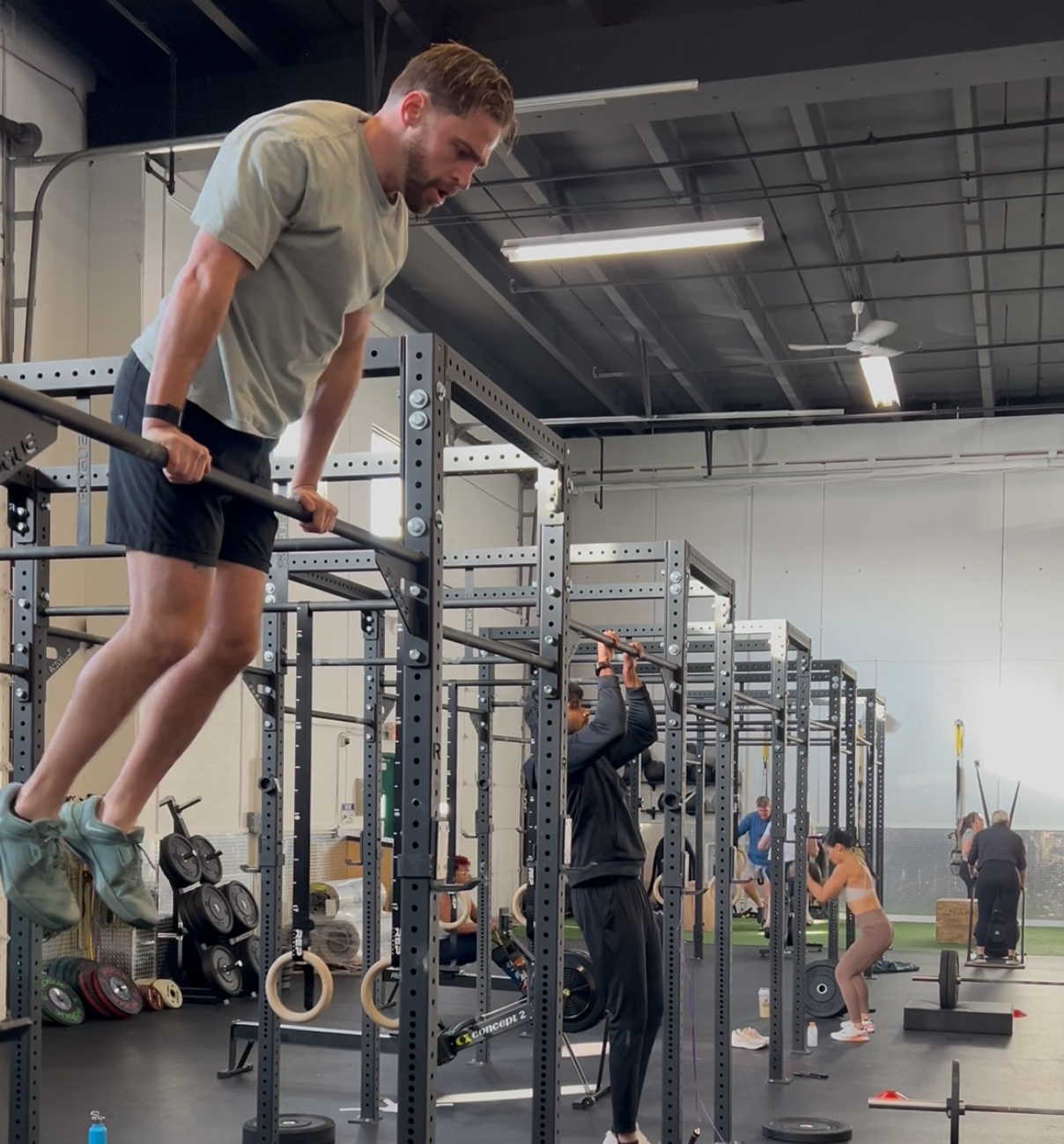 Man receiving physical therapy on a table. Therapist assists with arm/leg movements, indoor gym setting.