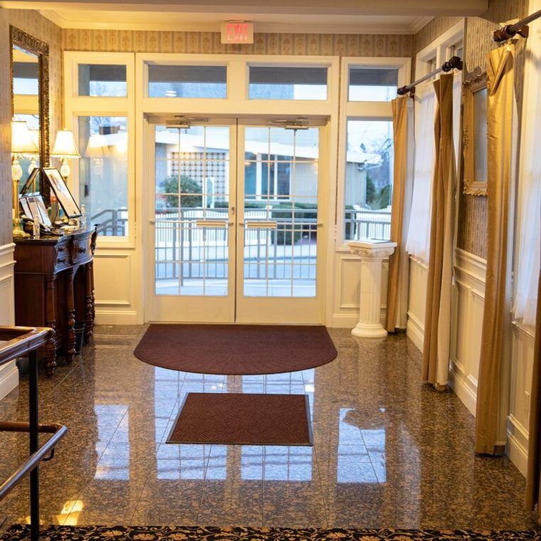 A hallway with a red exit sign above the door