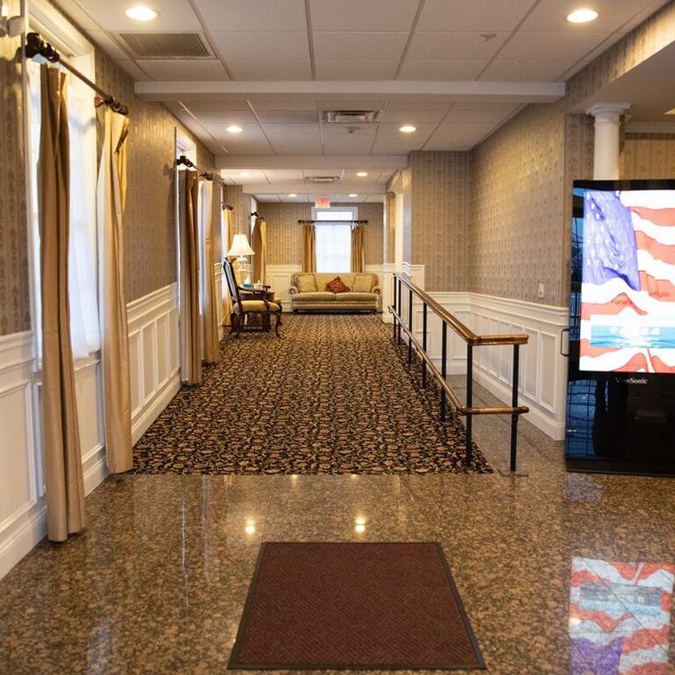 A long hallway leading to a living room with a flat screen tv