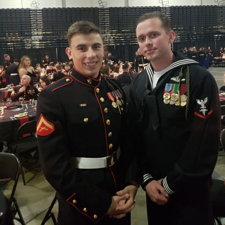 Two men in military uniforms are posing for a picture