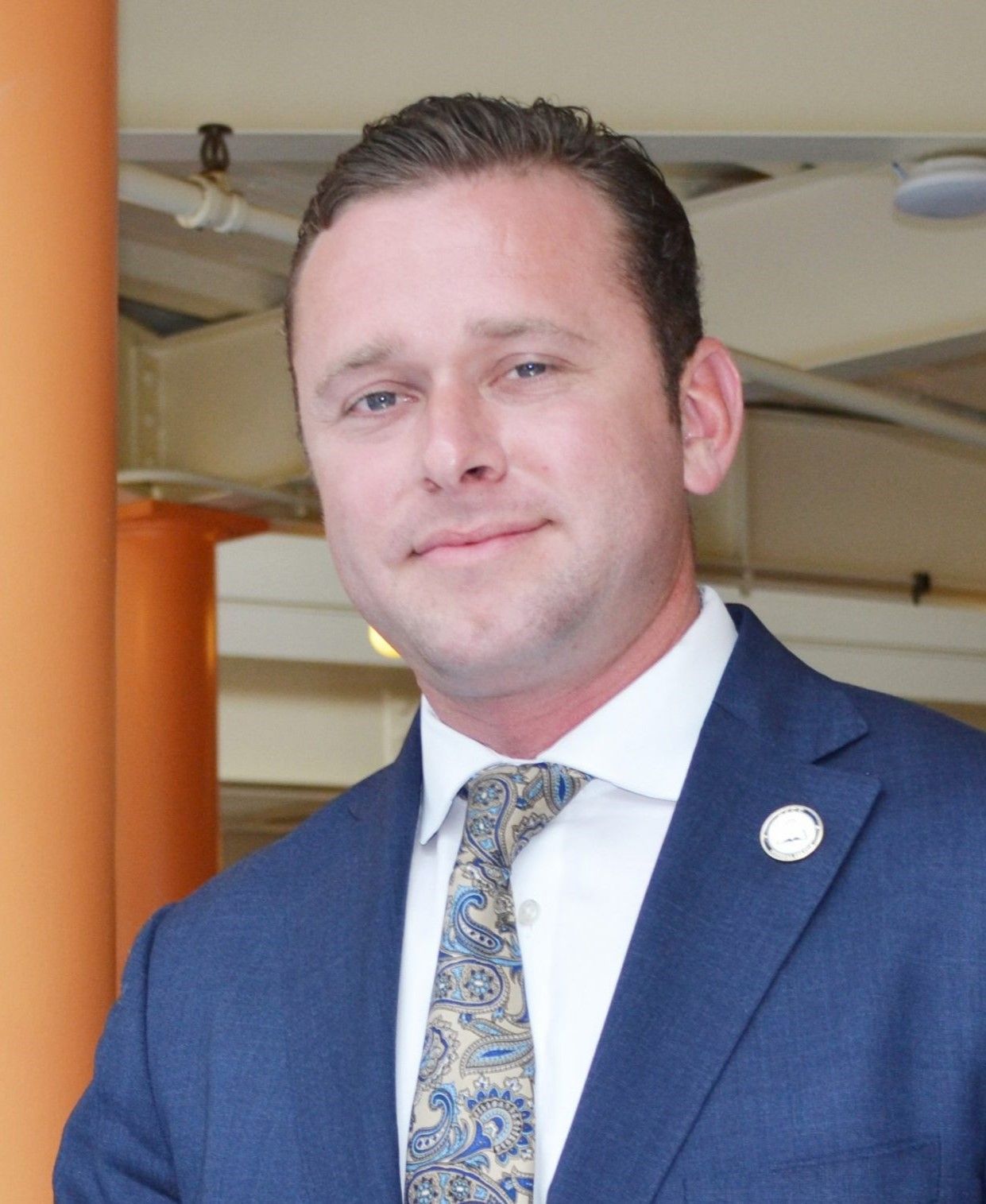 A man in a suit and tie is smiling for the camera