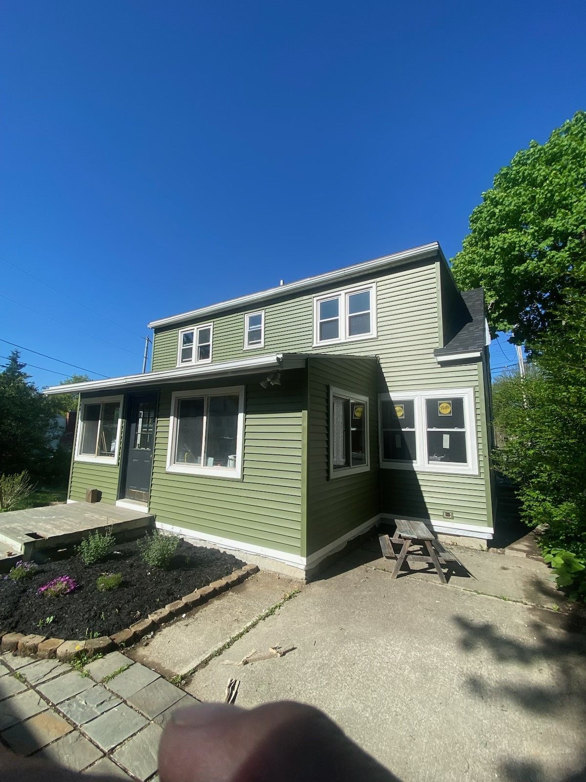 A green house with a picnic table in front of it.  - Kingston, NY - JMD Home Improvements