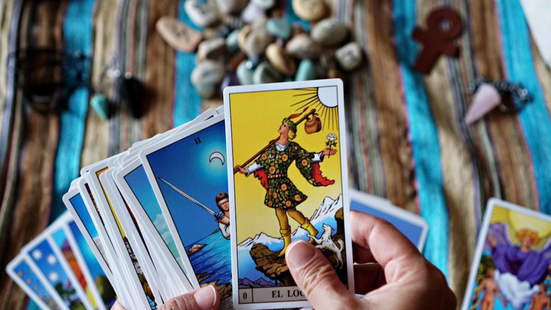 Manos sosteniendo cartas del tarot, con la carta de