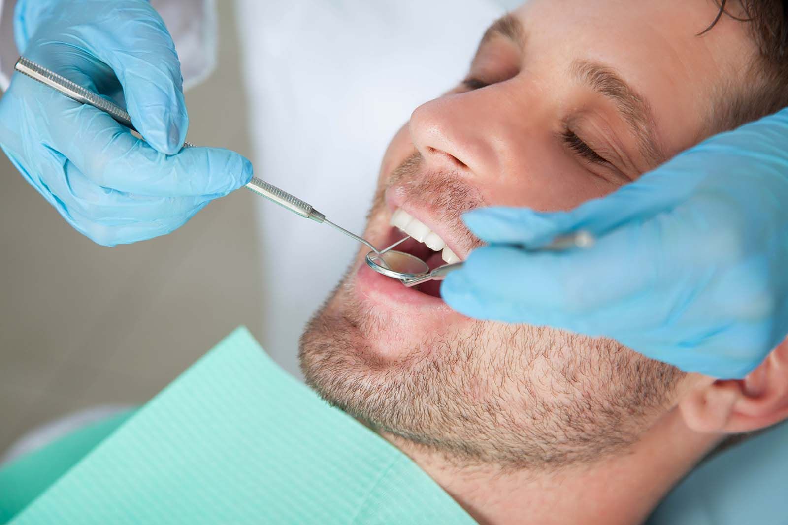 dentist performing gum health exam for periodontal disease in Babylon NY