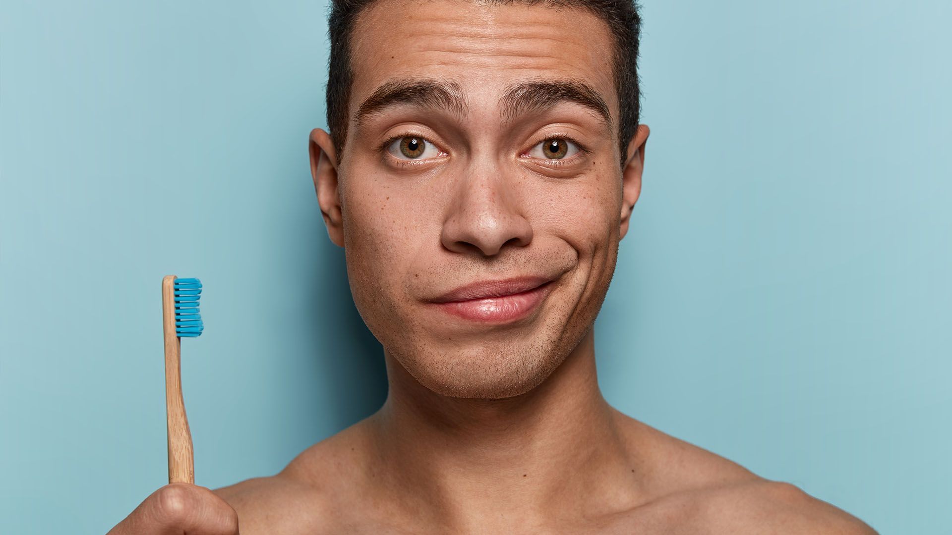Skeptical Expression holds a toothbrush