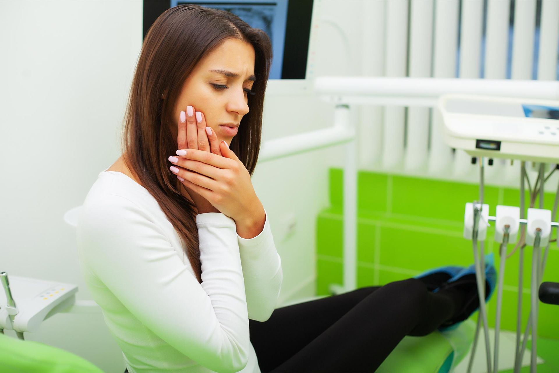 An up woman experiencing toothache at dental office, holding cheek in pain, illustrating the impact 