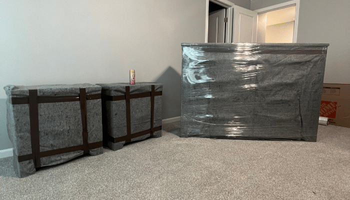 Two boxes wrapped in plastic are sitting on the floor in a room.