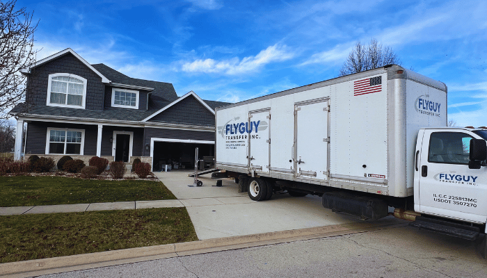 A moving truck is parked in front of a house.