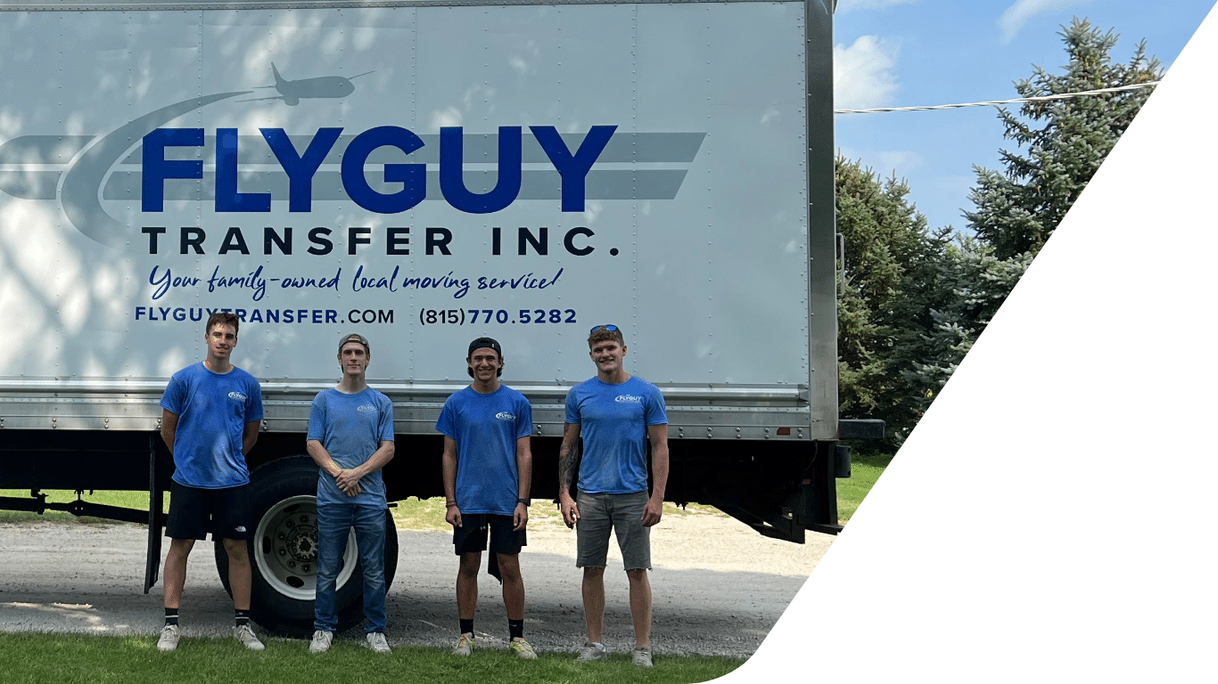 A group of men are standing in front of a white truck that says flyguy transfer inc.