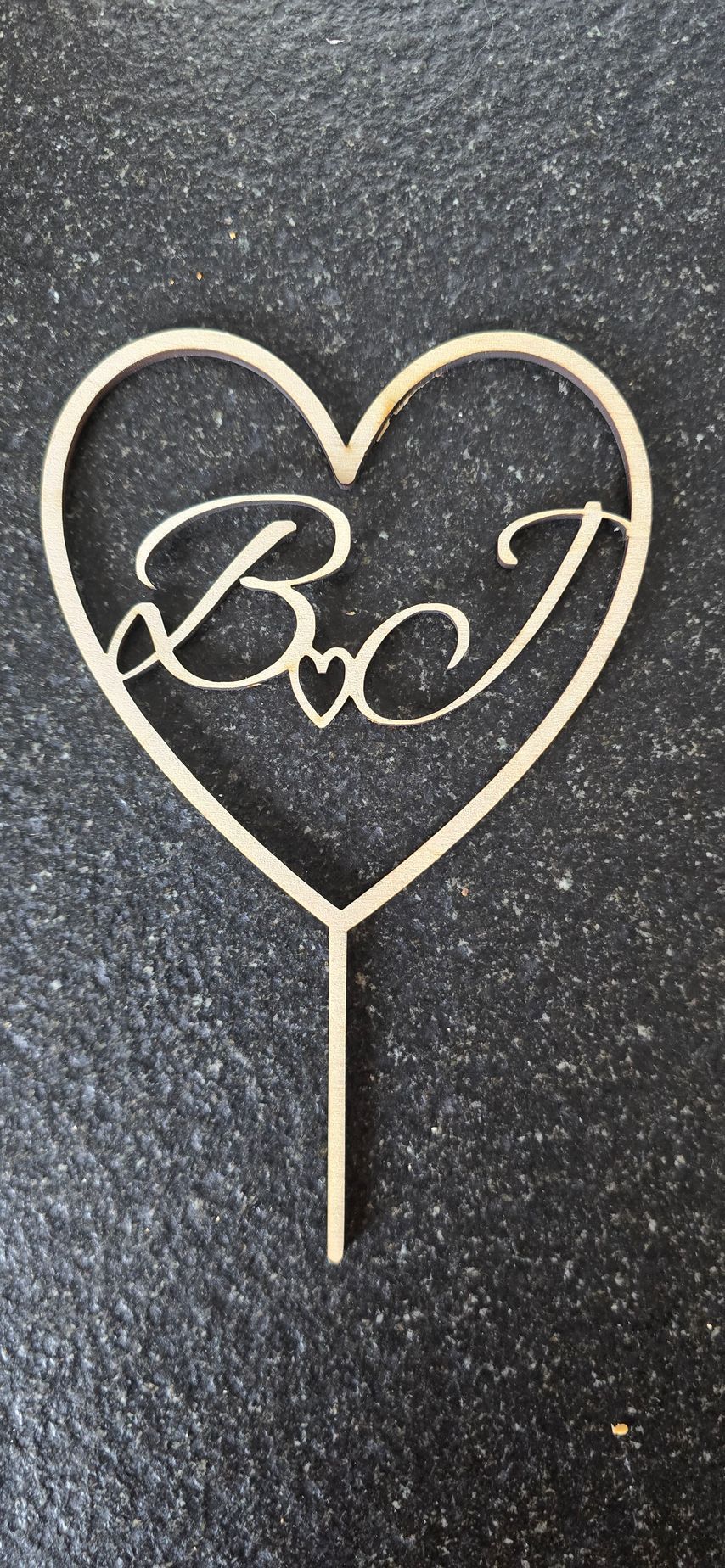 Wooden heart cake topper with the letters 