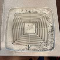 Square, dirty ceiling vent cover with a grid pattern.