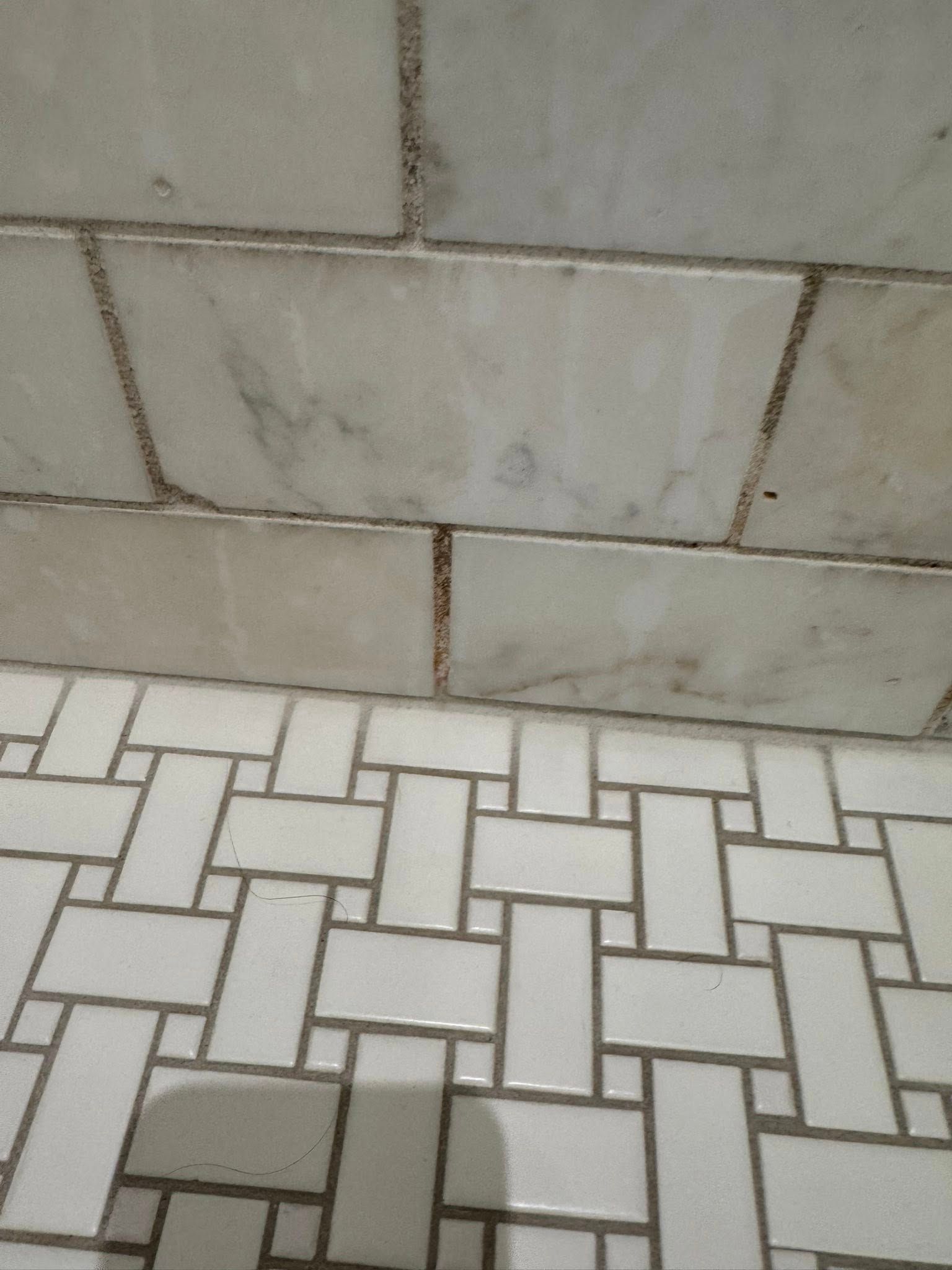 White bathroom tiles on wall and floor.