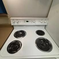 White electric stove with four burners, control panel, and a digital display.