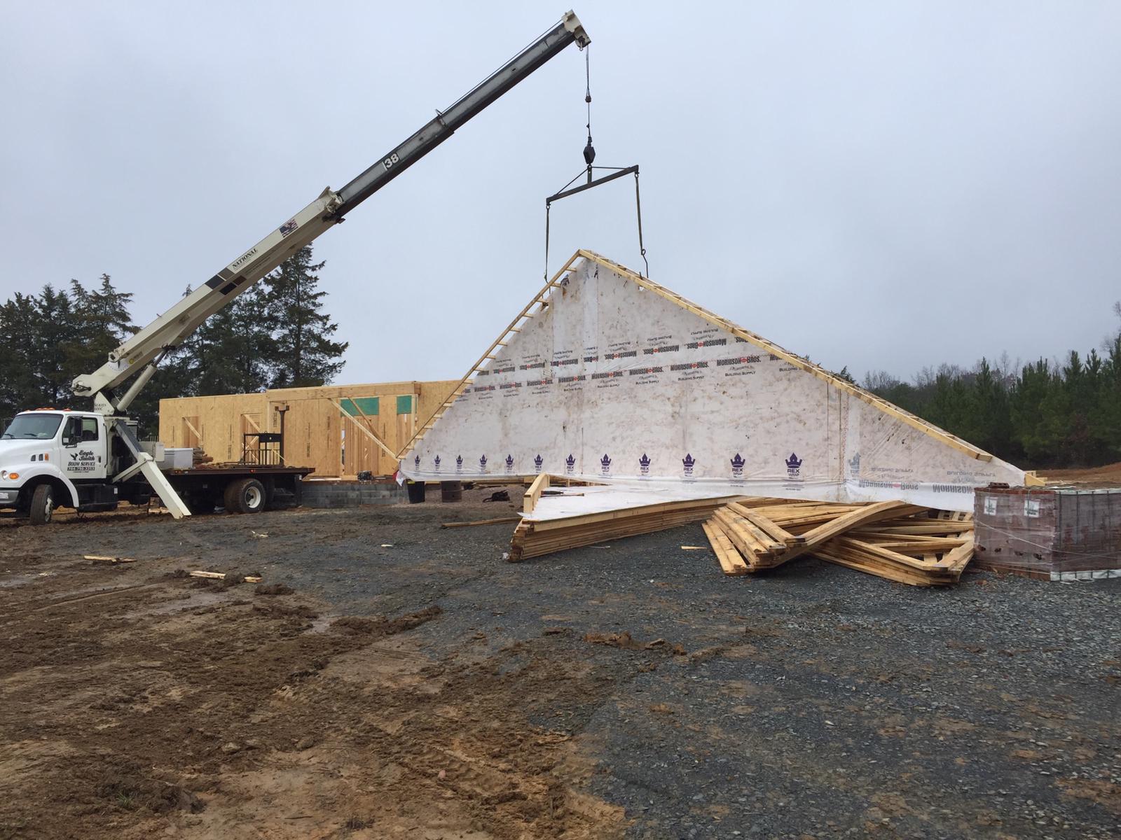 Section of roofing being lifted by crane service in Concord, NC