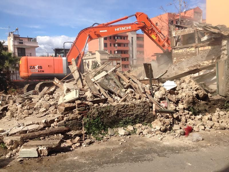 Un escavatore Hitachi sta demolendo un edificio