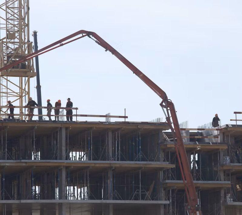 Un gruppo di operai edili in piedi sulla cima di un edificio in costruzione