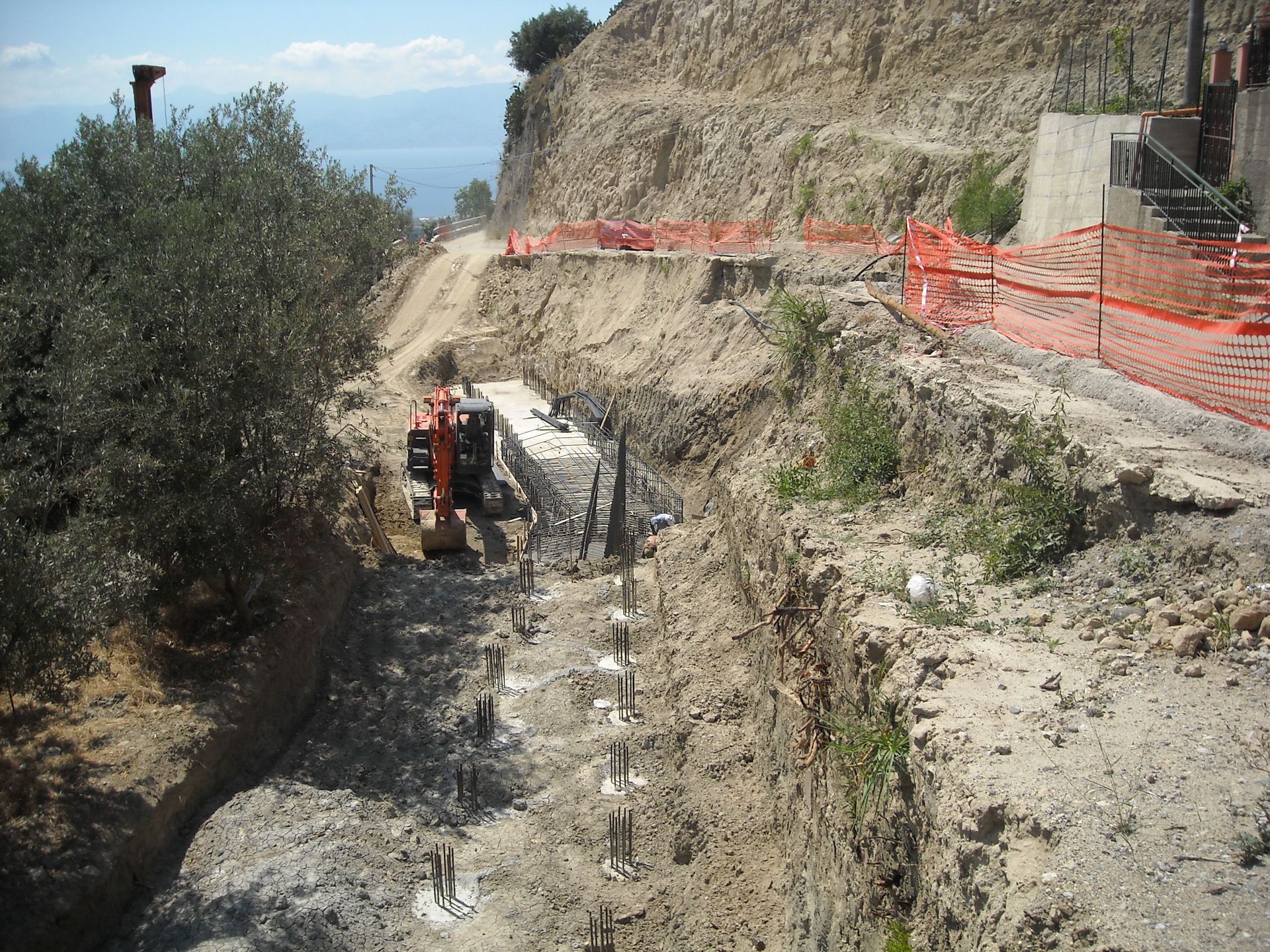 Un trattore sta percorrendo una strada sterrata accanto a una recinzione